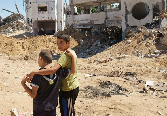 "Home Demolished" (2014).  Brothers in front of their home destroyed in 2014 by Israel.
