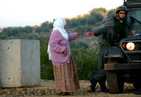"Carded" (2004).  Palestinian farmer from Jayyous checked by Israeli soldier (Photography Life).